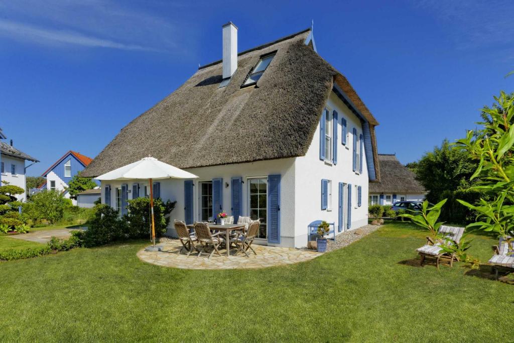a white house with a thatched roof at Ginsterweg 10 in Ostseebad Karlshagen