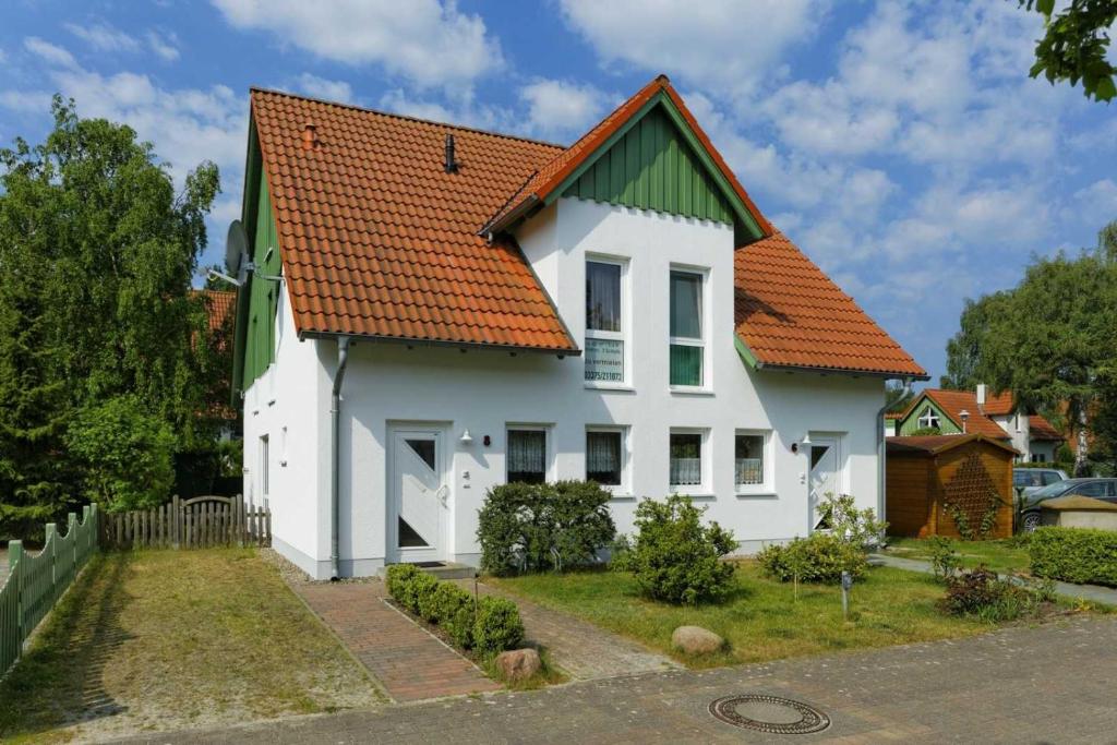 オストゼーバート・カールスハーゲンにあるWeidenweg 06のオレンジ色の屋根の白い家