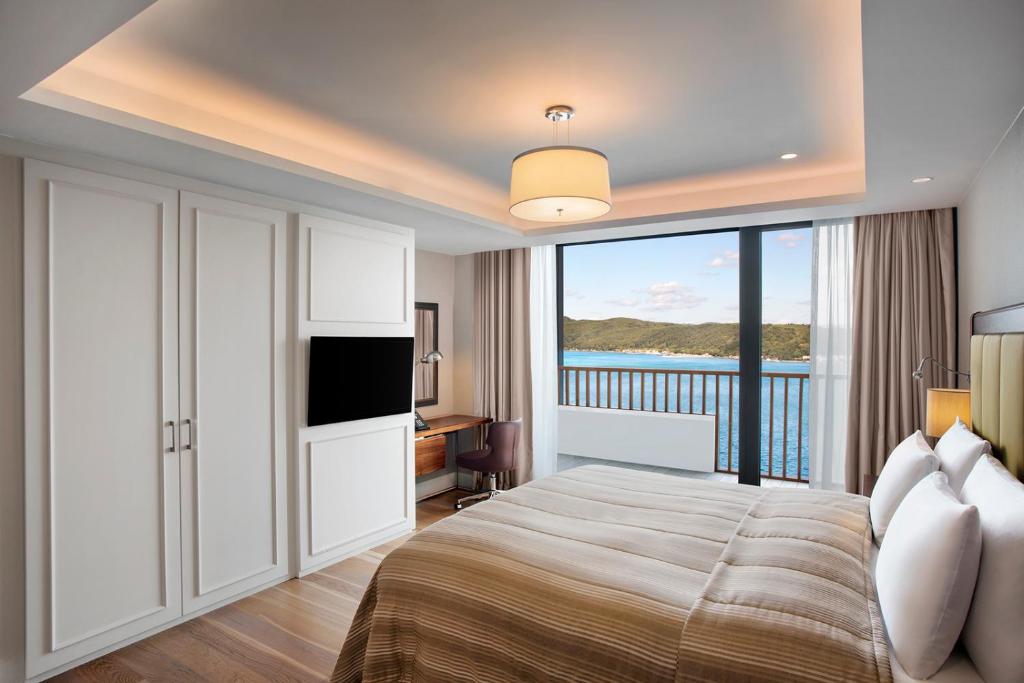 a bedroom with a bed with a view of the ocean at The Grand Tarabya Managed by Accor in Istanbul