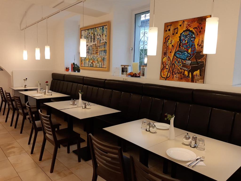 uma sala de jantar com mesas e cadeiras num restaurante em Hotel Aton em Graz