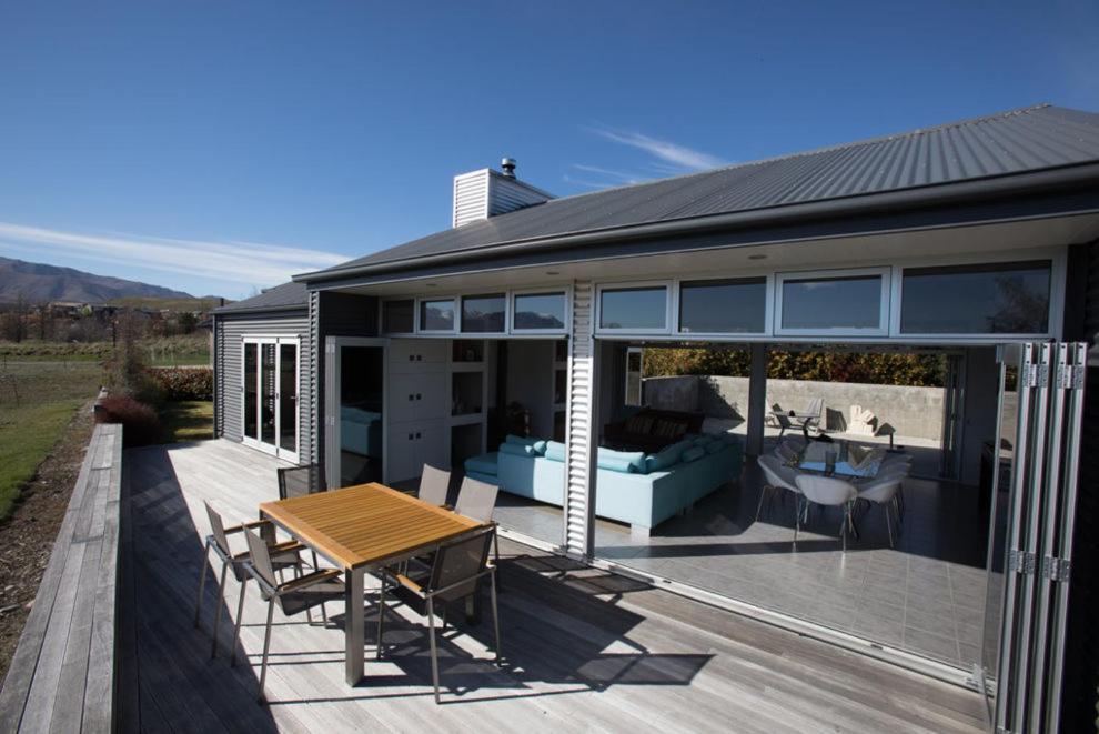 a house with a wooden table on a deck at Tekapo Retreat in Lake Tekapo