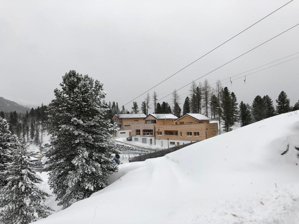a ski lodge on a snow covered slope with trees at Appartement am Berg in Ebene Reichenau