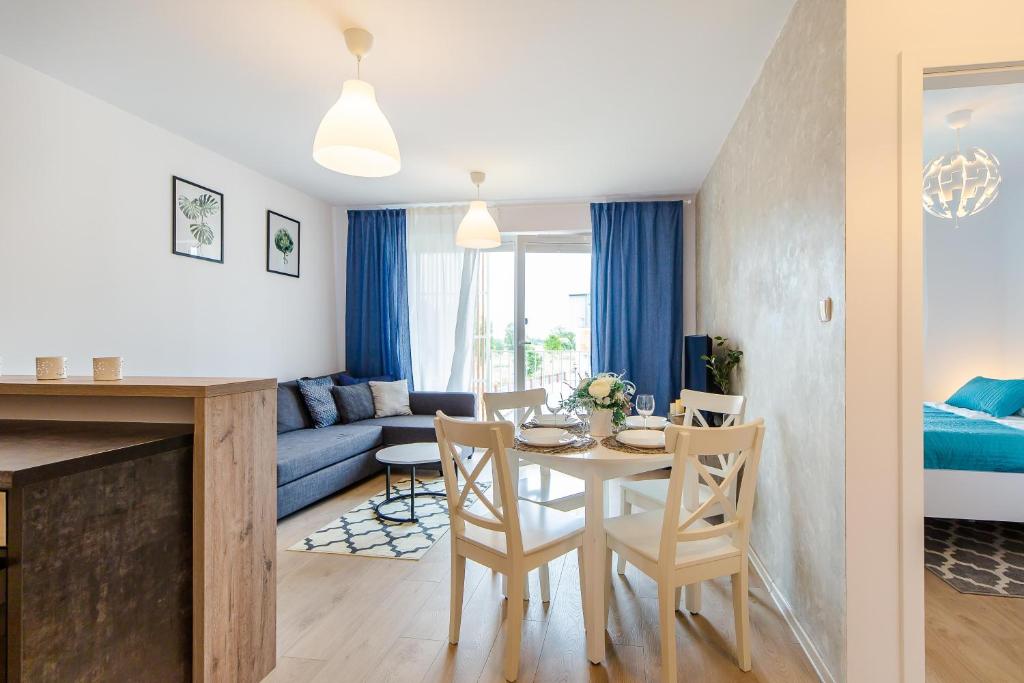 a kitchen and living room with a table and chairs at Apartamenty Familijne- Os Feniks in Kołobrzeg