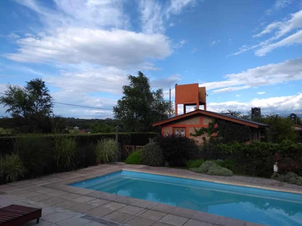 a house with a swimming pool in front of a house at Cabañas El Quijote in Los Reartes