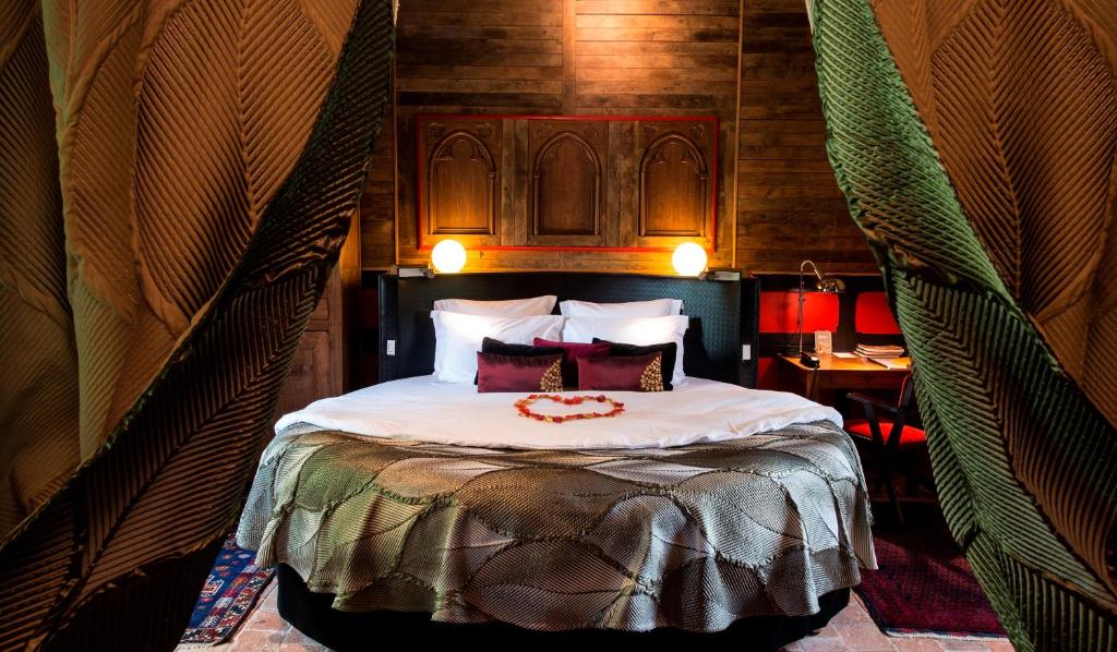 a bedroom with a large bed in a room at Le Portail en Marais Poitevin - Logis d'Exception - Jacuzzi Privatif in Moreilles