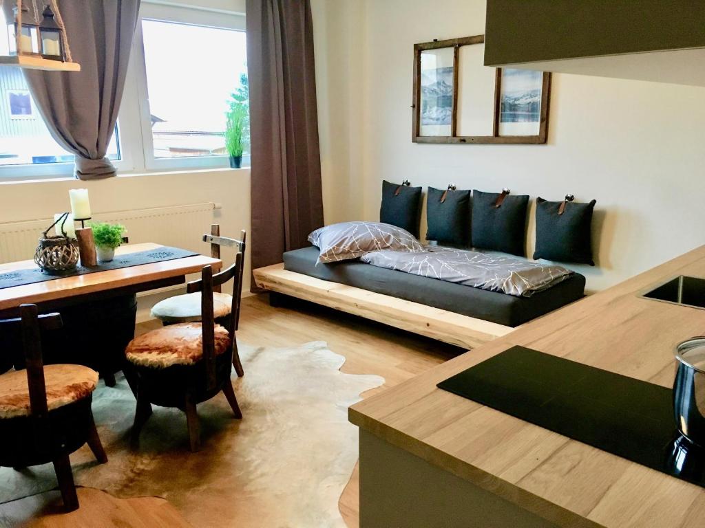 Sala de estar con cama y mesa en Alpenstyle Apartment neben der Therme, en Bad Wörishofen