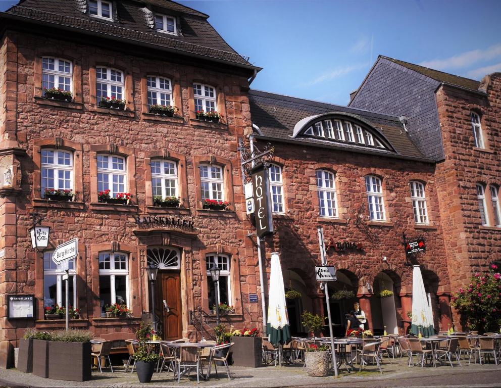 a brick building with tables and chairs in front of it at Hotel Ratskeller in Nideggen