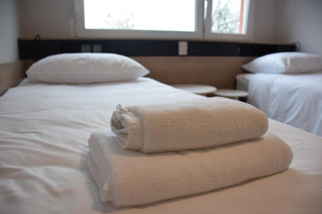 2 toallas están apiladas en la parte superior de una cama en Accommodation Vitalis en Liubliana