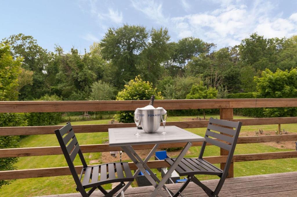 a tea kettle sitting on a table on a deck at Les Jardins d'Ulysse, The Originals Relais (Relais du Silence) in Stella-Plage