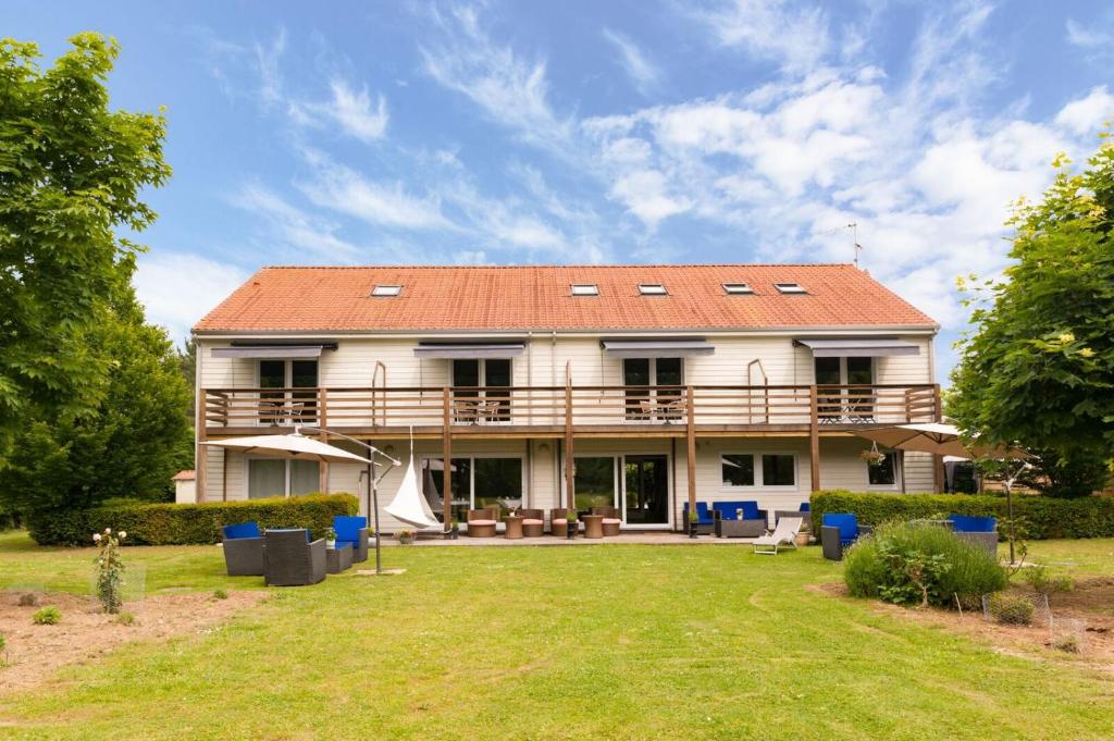 a large white house with a red roof at Les Jardins d'Ulysse, The Originals Relais Le Touquet in Stella-Plage
