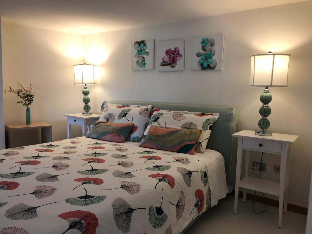 - une chambre avec un lit avec une couette et 2 lampes dans l'établissement Casa di Erminia, à Naples