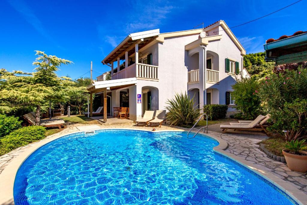 een villa met een zwembad voor een huis bij Villas Rab Banjol in Rab
