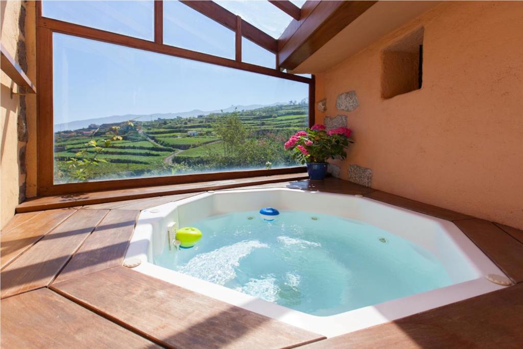 a jacuzzi tub in a room with a large window at Rural Las Llanadas in Los Realejos