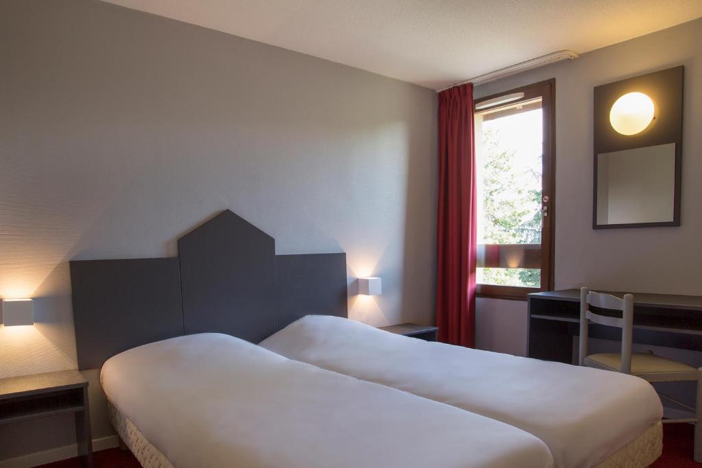 a hotel room with two beds and a window at The Originals City, Hôtel Amys, Tarbes Sud (Inter-Hotel) in Odos