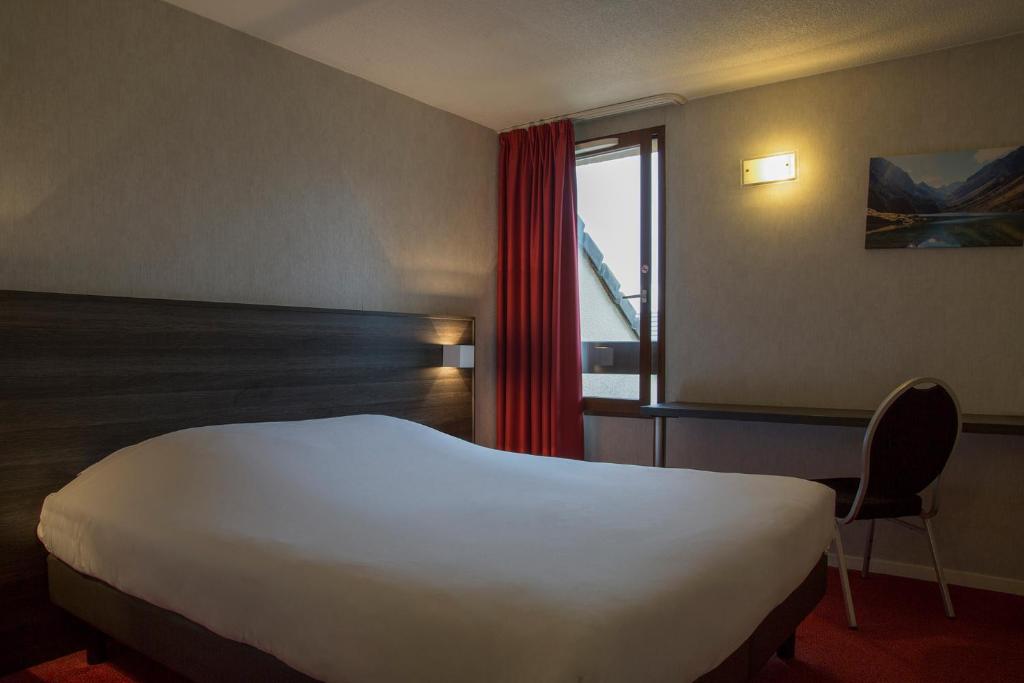 a hotel room with a bed and a window at The Originals City, Hôtel Amys, Tarbes Sud (Inter-Hotel) in Odos