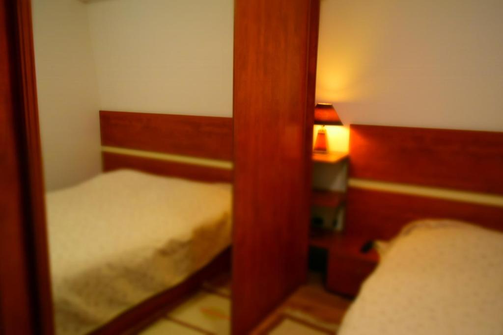a small room with two beds and a mirror at Vučko Apartment in Bjelašnica