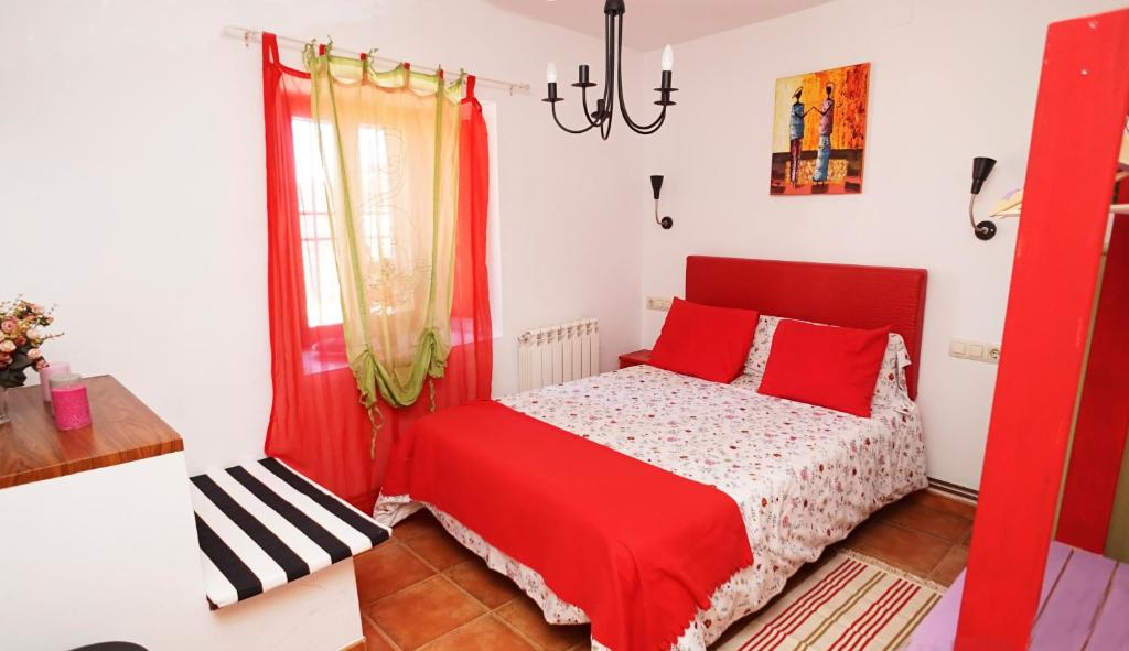 a bedroom with a red bed and a window at Casa Gatos in Toledo