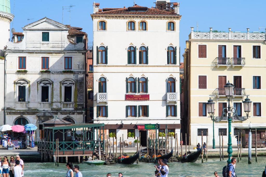 
people are walking in the water near a building at Hotel Antiche Figure in Venice
