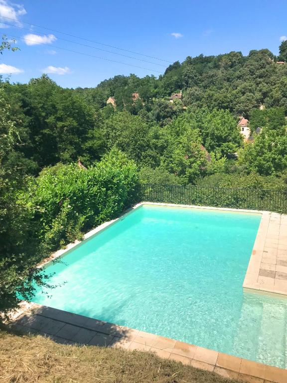 une piscine d'eau bleue et d'arbres dans l'établissement Maison La Mouline, à Groléjac