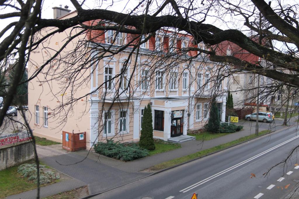 un gran edificio blanco al lado de una calle en Hotel Polonia, en Chojnice
