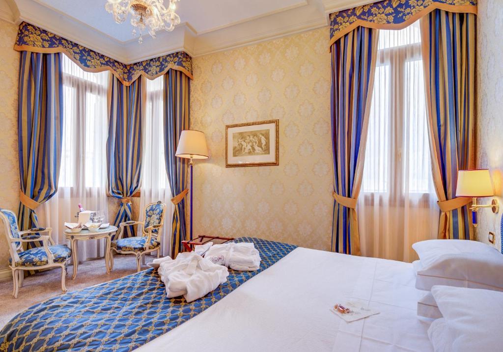 a hotel room with a large bed and curtains at Hotel Antiche Figure in Venice