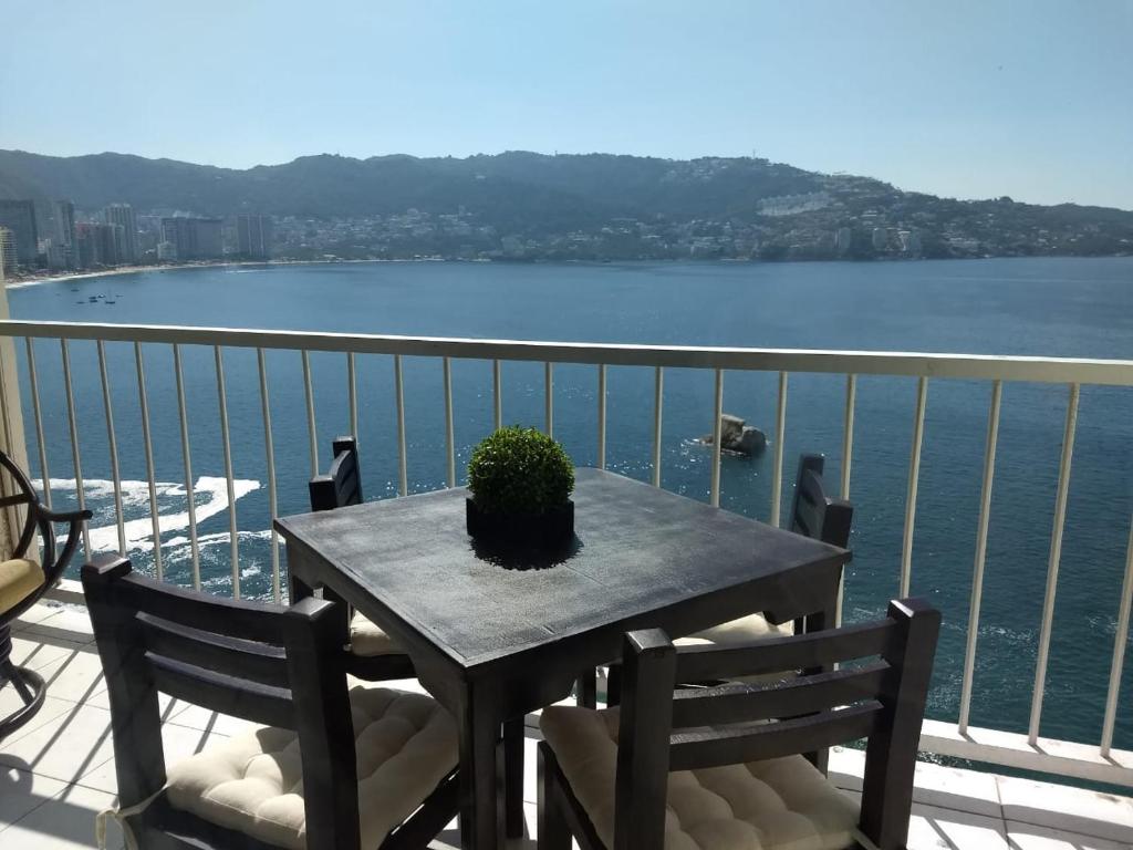 une table avec une plante en pot au-dessus d'un balcon dans l'établissement SUITE SELECT TORRES GEMELAS, à Acapulco