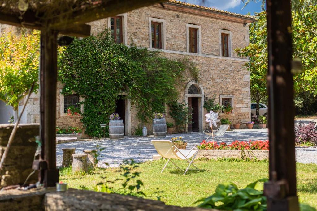 a house with two chairs in front of it at Agriturismo Tenuta Armaiolo in Rapolano Terme