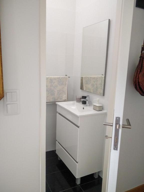 a bathroom with a white sink and a mirror at Casa da Tia Adozinda in Lisbon