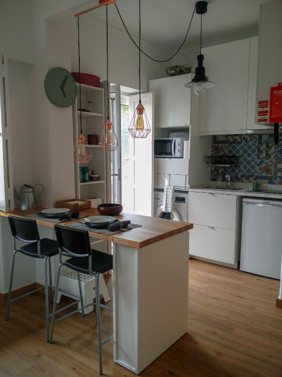 a kitchen with a island with chairs and a table at Casa da Tia Adozinda in Lisbon
