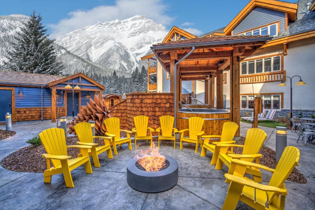 a patio with yellow chairs and a fire pit at Canalta Lodge in Banff