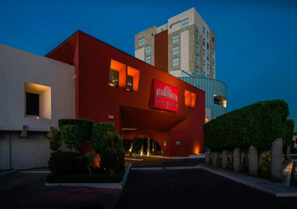 a red building with a sign on the side of it at Hotel Puente Real in Puebla
