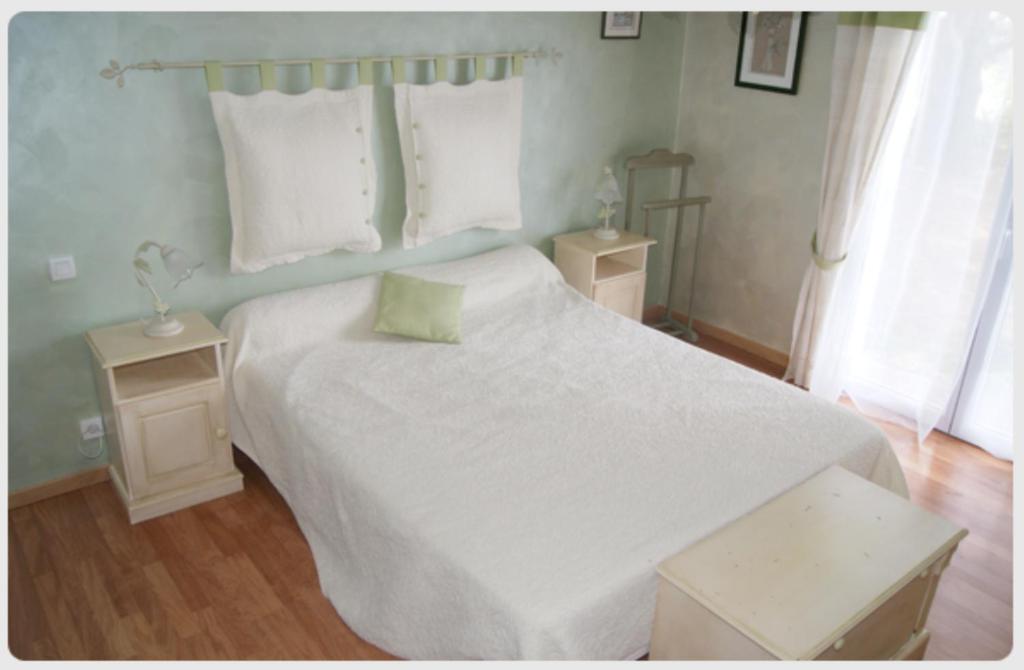 PlouhinecにあるMaison d'Hôtes de Kerzineのベッドルーム1室(大きな白いベッド1台、テーブル2台付)