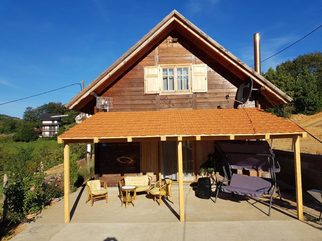 un padiglione con tavolo e sedie di fronte a una casa di Stara Planina Stankovic a Crni Vrh