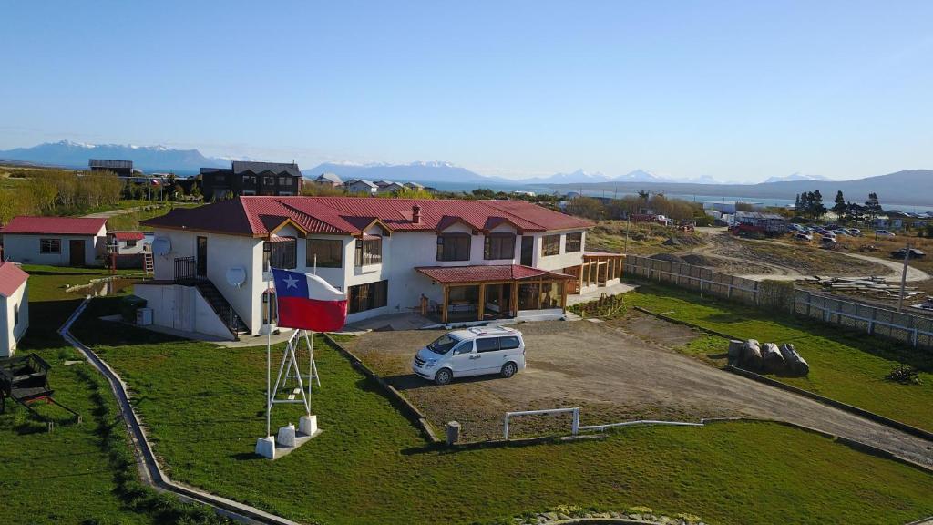 een wit busje geparkeerd voor een huis bij Hostal Doble E Patagonia in Puerto Natales