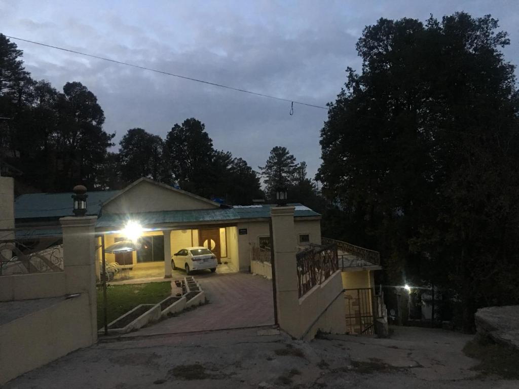 a house with a car parked in a driveway at night at Rashk e Qamar in Murree