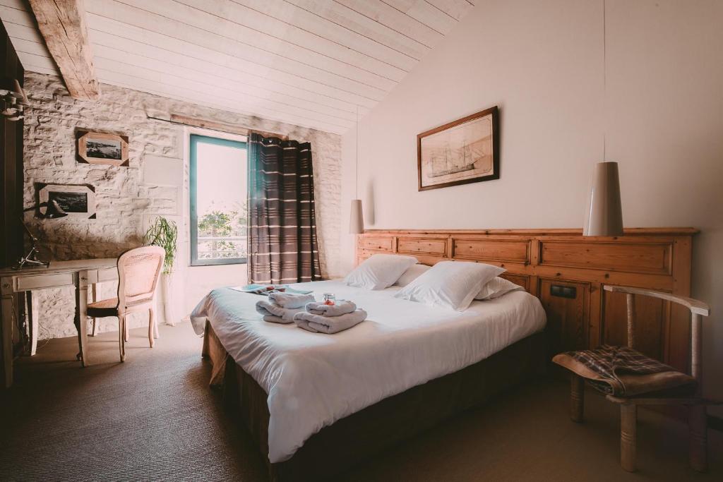 a bedroom with a bed and a table and a window at Un Banc au Soleil in Marsilly