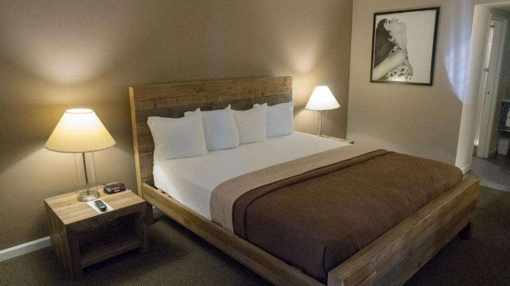ein Schlafzimmer mit einem großen Bett und zwei Lampen in der Unterkunft Thunderbird Boutique Hotel in Las Vegas