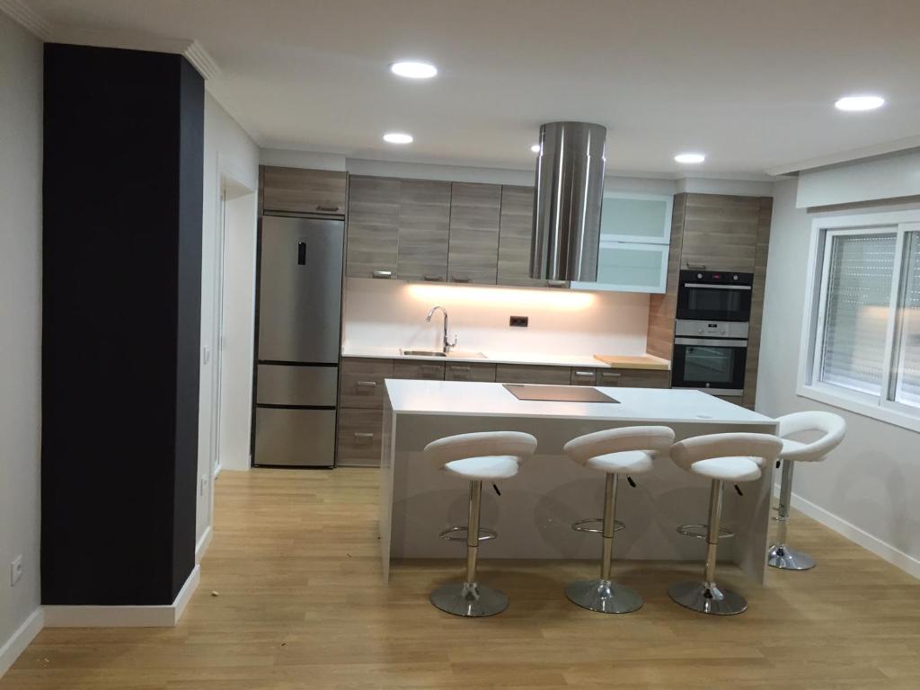 a kitchen with a island with bar stools at Piso en O Grove in O Grove