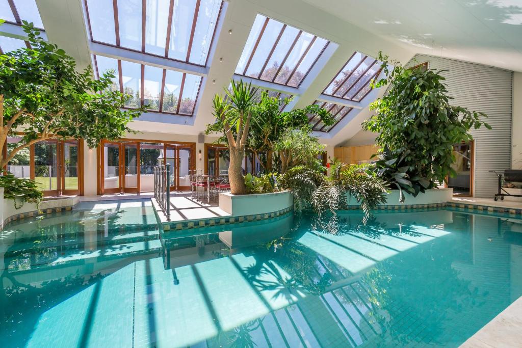 a swimming pool in a building with windows at BOND ESTATE LUXURY ACCOMMODATION in Christchurch
