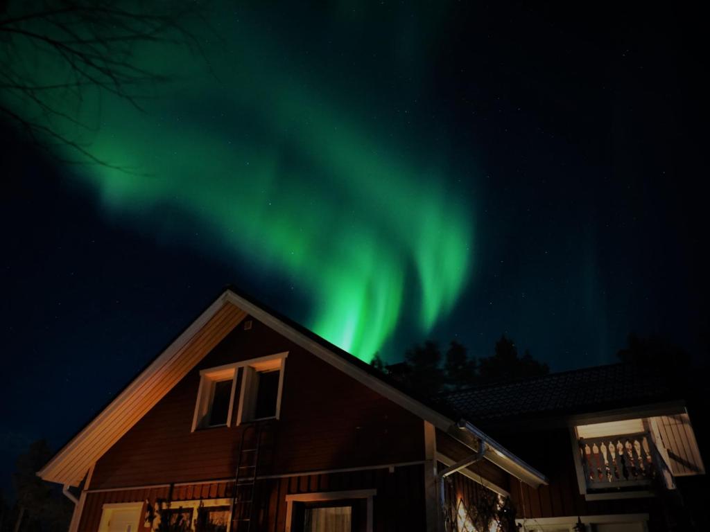 a house with the aurora in the sky at Apartment Neitamo44 in Ivalo
