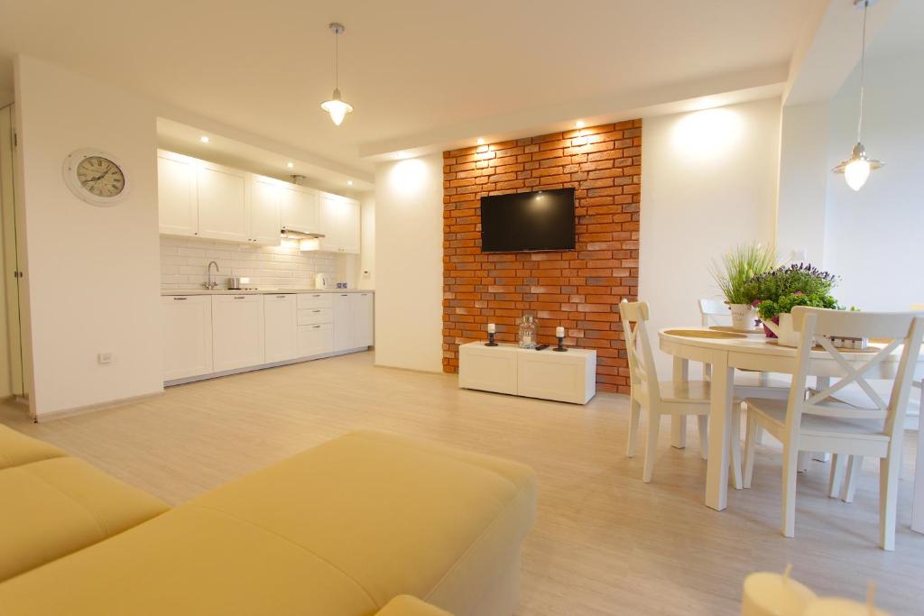 ダルウフコにあるBaltic Korona Apartamenty D17のリビングルーム(ソファ、テーブル付)、キッチンが備わります。