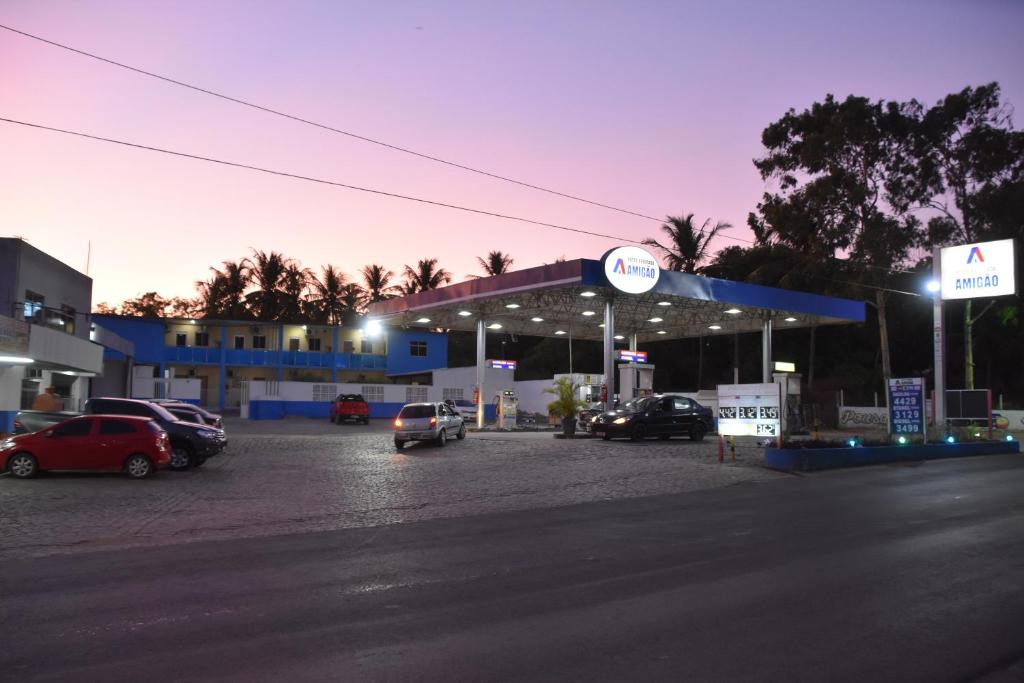 eine Tankstelle mit Autos auf einem Parkplatz in der Unterkunft Pousada e Posto Amigão in São Gonçalo do Amarante