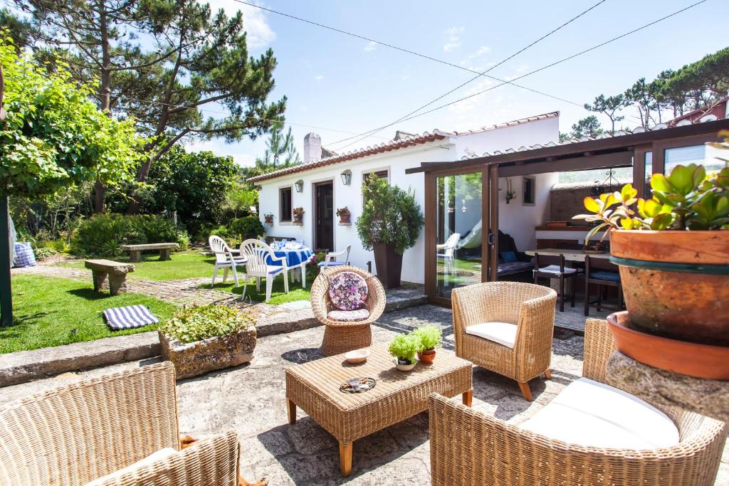 eine Terrasse mit Korbstühlen und einem Tisch in der Unterkunft Beautiful Country House&Romantic Garden in Sintra