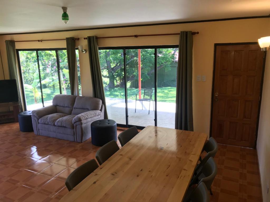 una sala da pranzo con tavolo, sedie e divano di Cabañas Tautira a Hanga Roa