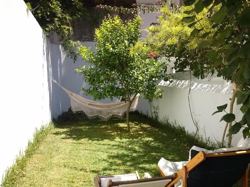 リスボンにあるCasa com Jardim privadoの木の植わる庭園のハンモック