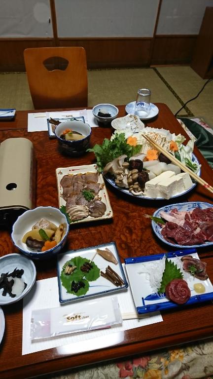 una mesa con muchos platos de comida. en Minshuku Yurika, en Urugi