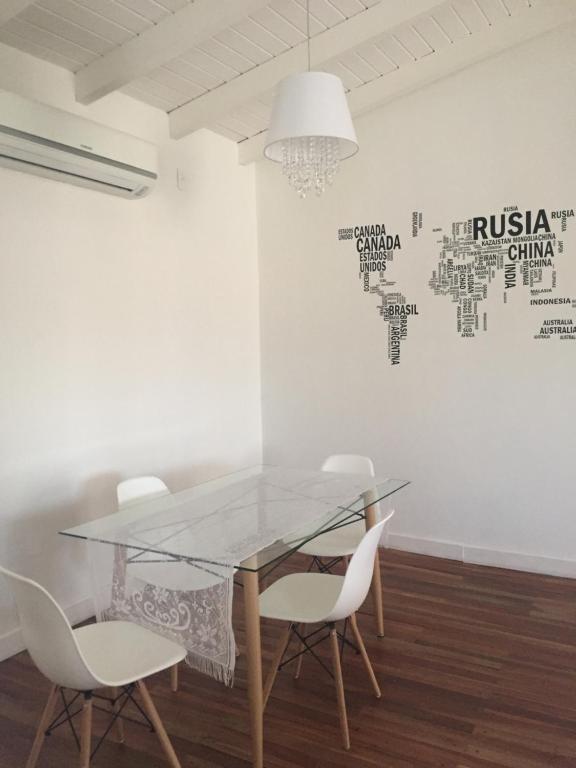 a dining room with a glass table and white chairs at Dpto. Tribuno in Salta