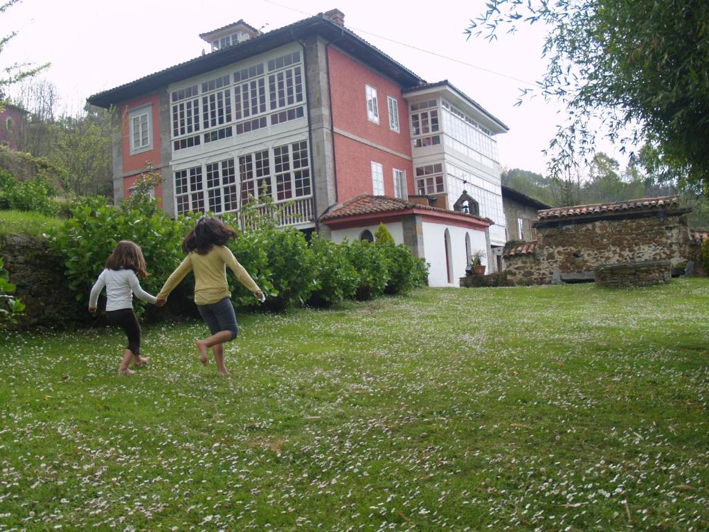 dos niños jugando en el césped frente a una casa en Hotel Palacio de Libardon en Libardón