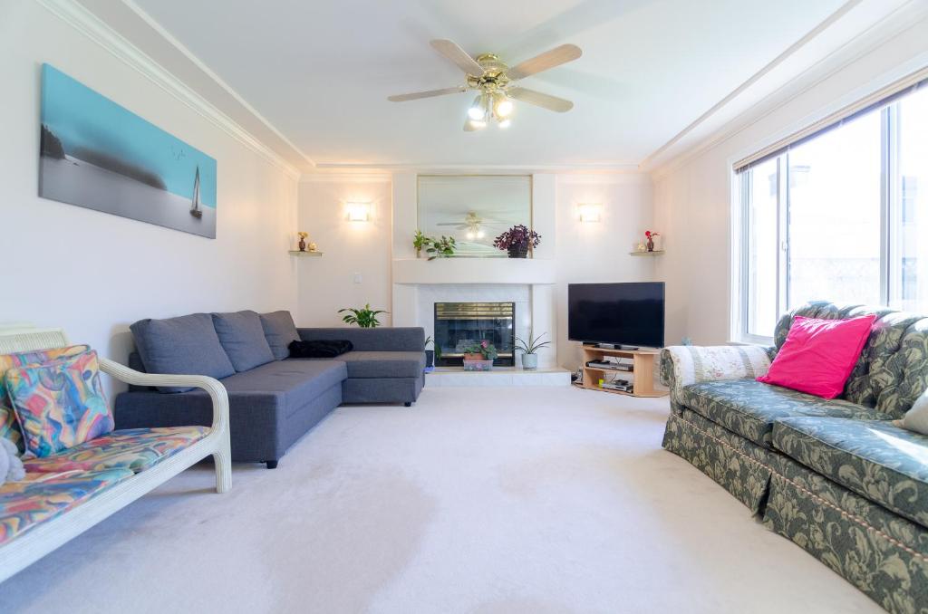 ein Wohnzimmer mit 2 Sofas und einem TV in der Unterkunft Great Guest Suite in a Gorgeous House in New Westminster