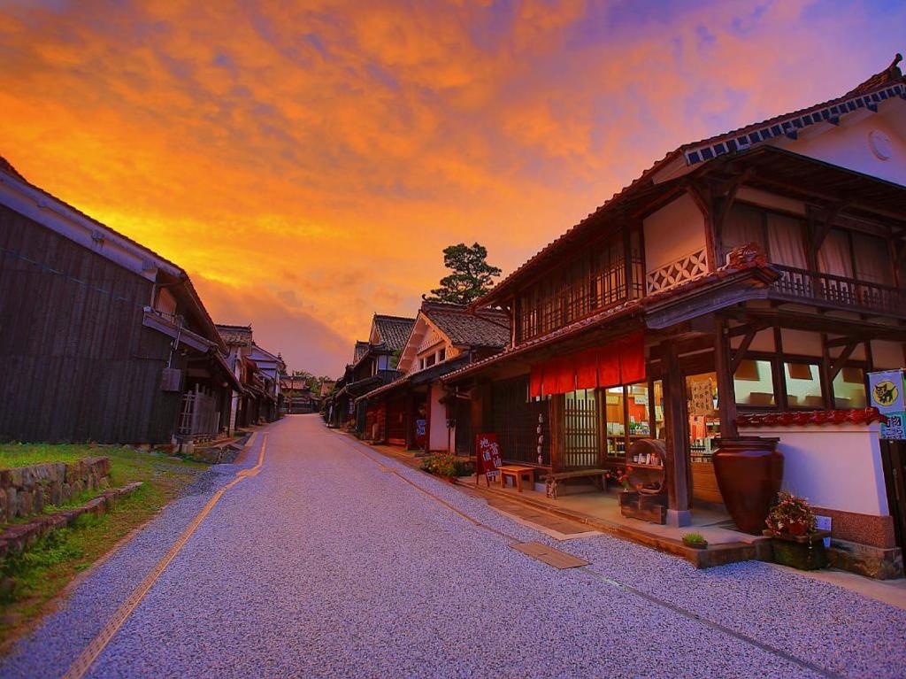 una calle vacía en un pueblo con una puesta de sol en Guest House Eleven Village Fukiya en Fukiya